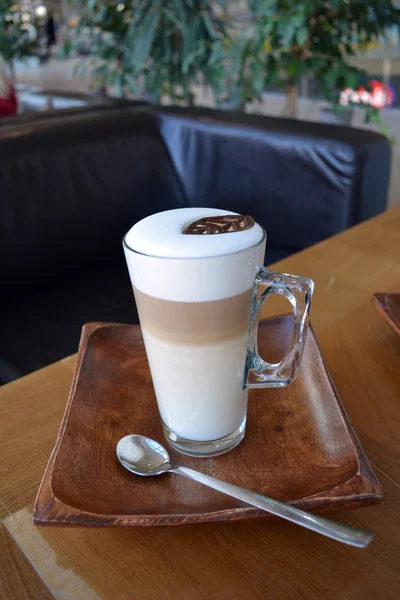 Latte Macchiato en copa de vidrio en la mesa de madera — Foto de Stock