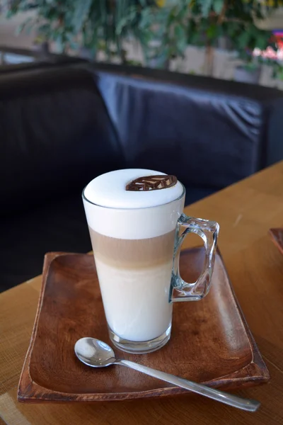 Latte Macchiato im Glasbecher auf dem Holztisch — Stockfoto