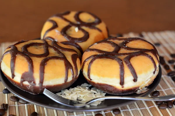 Tres rosquillas tradicionales con chocolate en el plato marrón —  Fotos de Stock