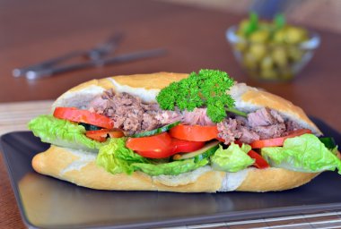 Ton balığı baget kahverengi tabakta sebze ile