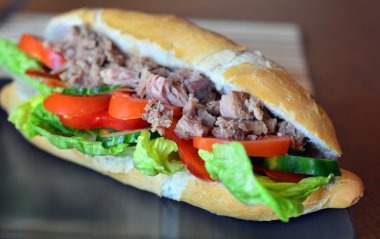 Ton balığı baget kahverengi tabakta sebze ile