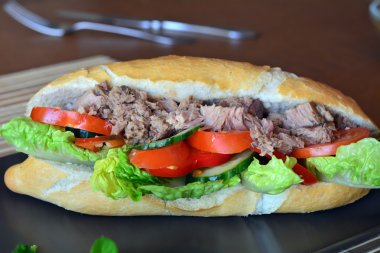 Ton balığı baget kahverengi tabakta sebze ile