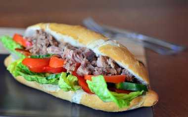 Ton balığı baget kahverengi tabakta sebze ile