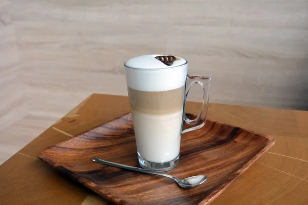 Latte Macchiato em copo de vidro na mesa de madeira — Fotografia de Stock