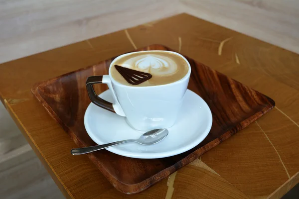 Cup of delicious cappuccino on a wooden table — Stock Photo, Image