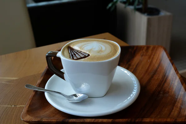 Cup of delicious cappuccino on a wooden table — Stock Photo, Image