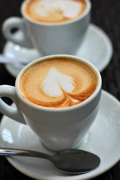 Cup of delicious cappuccino on a wooden table — Stock Photo, Image