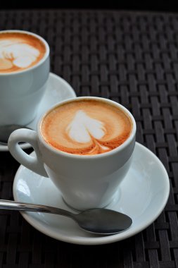 Xícara de cappuccino espumante delicioso em um fundo preto