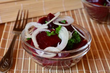 切好的新鲜甜菜根沙拉配洋葱和香菜上一个玻璃碗