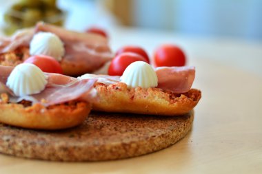Bruschetta kekik, prosciutto ve mozzarellalı ahşap bir masa üzerinde