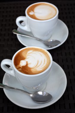 Siyah arka plan üzerine lezzetli köpüklü kapuçino