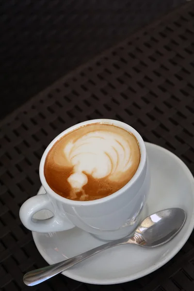 Delicioso capuchino espumoso sobre el fondo negro — Foto de Stock