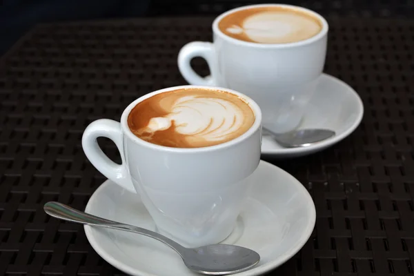 Köstlicher schäumender Cappuccino auf schwarzem Hintergrund — Stockfoto