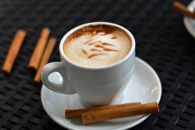 Siyah arka plan üzerine lezzetli köpüklü kapuçino fincan