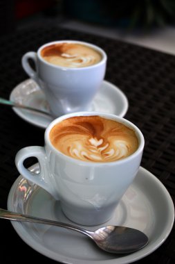 Siyah arka plan üzerine lezzetli köpüklü kapuçino fincan