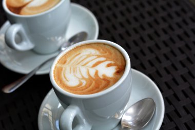 Köpüklü Cappuccino siyah bir zemin üzerine beyaz fincan