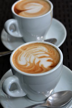 Köpüklü Cappuccino siyah bir zemin üzerine beyaz fincan