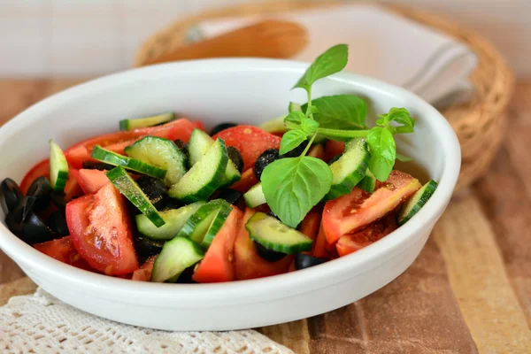 Ensalada de verduras saludables con pepino, tomates en un tazón de porcelana blanca — Foto de Stock