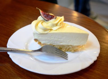 Dilim cheesecake ahşap bir masa üzerinde bir plaka üzerinde