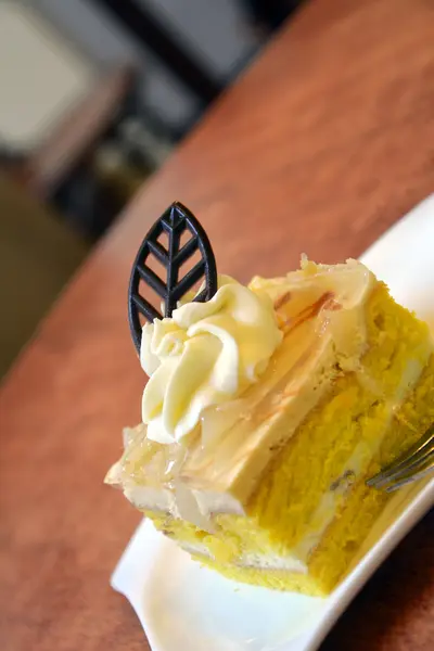 Kawałek ciasta gruszki krem na płytce na drewnianym stołem — Zdjęcie stockowe