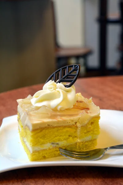 Kawałek ciasta gruszki krem na płytce na drewnianym stołem — Zdjęcie stockowe