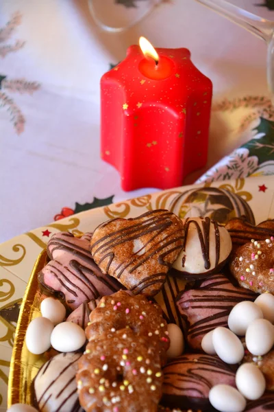 Detalle de deliciosas galletas de Navidad con velas en tono rojo — Foto de Stock