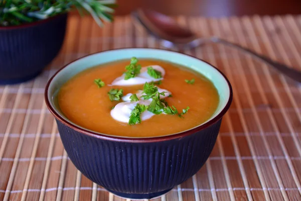 Cremosa sopa de calabaza de mantequilla en un tazón de cerámica en una mesa —  Fotos de Stock