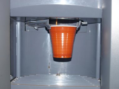 bir kahve makinesi plastik cu içine kahve döker