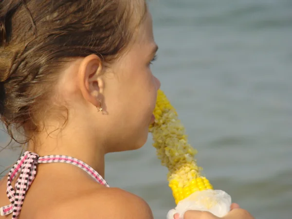 Kid Meisje Eten Maïs Zee Achtergrond — Stockfoto