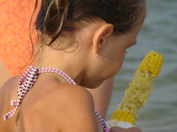 Kid Meisje Eten Maïs Zee Achtergrond — Stockfoto