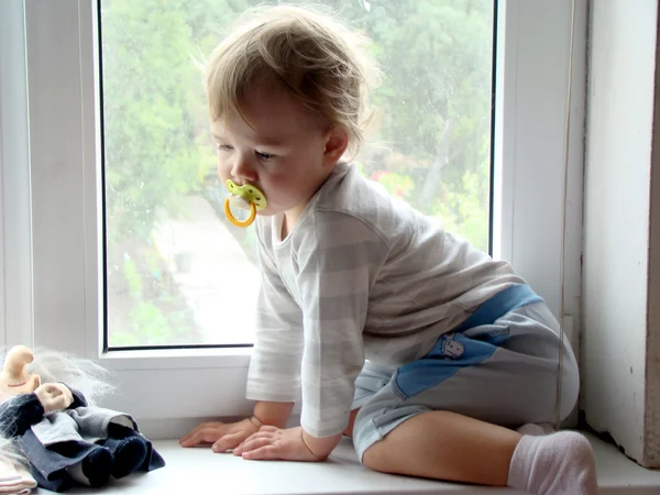 Ребенок сидит на окне — стоковое фото