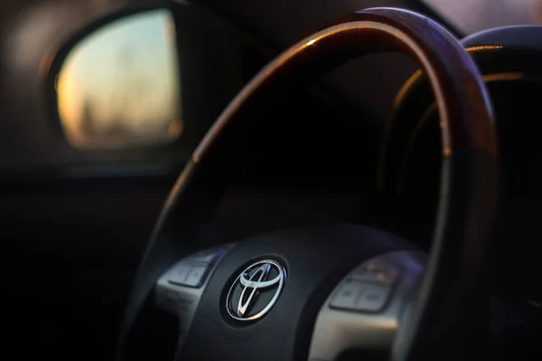 Vista del interior negro de toyota camry con tablero de instrumentos, sistema de medios, dirección y cambio de marchas. El volante del Toyota. Imagen De Stock