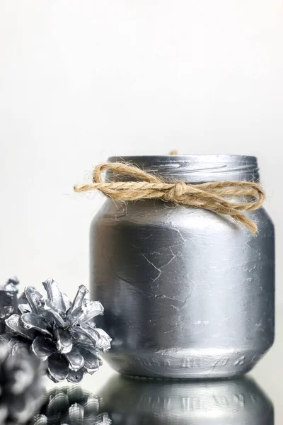 Haber Yılları Dekorasyonu. Diy. Yılbaşı mumları gümüş renginde, kendi elleriyle. Gümüş mum ve köknar kozalaklarının yakın çekimi. Yeni Yıl resmi