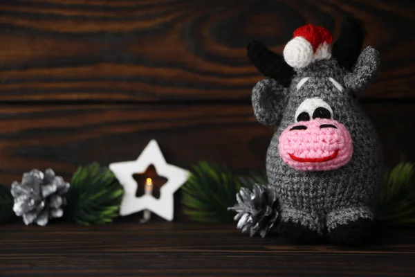 Karanlık bir arka planda, Noel ağacı ve yılbaşı kartı olan bir oyuncak boğa. 2021 yılının sembolü olarak boğa. Yeni yıl Noel 'i.