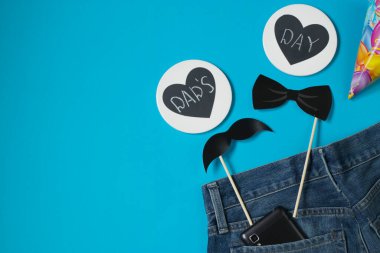 Babalar günün kutlu olsun. Mavi arka planda, siyah bıyık, papyon, melon şapka, üzerinde babalar günü yazan iki kalp. Mavi adamın kotunda bir cep telefonu. Boşluğu kopyala.