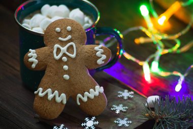 Sıcak bir içecek, lokum ve güzel çelenkli köknar dalları olan bir Noel kupası. Zencefilli kurabiye figürü yaklaş. Yeni yıl kutlaması.