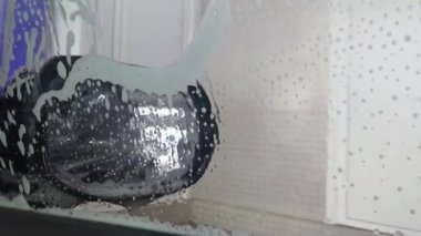 Otomatik yıkama makinesinde yıkanan içerideki arabanın görüntüsü. Araba yıkama servisi iş başında. Sıcak hava akışıyla kurumak. Yıkamanın son kısmı