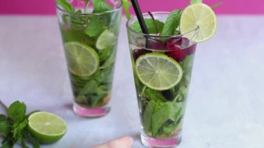 İki cam bardakta alkolsüz soğuk mojito. Limonata ve arkaplanda nane şekeri.