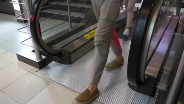 쇼핑몰에서 에스컬레이터를 타고 내려가는 발의 근접 사진 — 비디오
