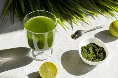 Klorelladan arınmak için bardakta limon ve barut var. Süper yiyecek, yeşil diyet için doğal antioksidan. Yaşlanma karşıtı etki. Sert gölgeler