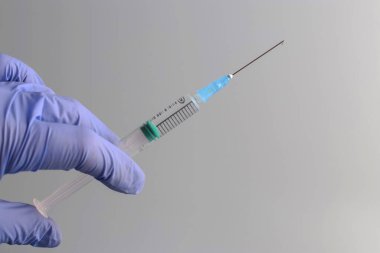 COVID19 aşısı kavramı, nCoV 2019. Tıbbi eldivenli bir doktorun ellerinde aşıyla dolu bir şırınga var. Koronavirüs enfeksiyonunu önleme, aşılama ve tedavi. Boşluğu kopyala