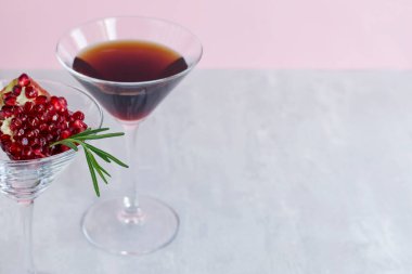 Açık pembe arka planda biberiyeli alkolsüz nar kokteyli. Doğal sağlıklı içecek. Boşluğu kopyala.