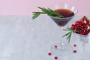 Açık pembe arka planda biberiyeli alkolsüz nar kokteyli. Doğal sağlıklı içecek. Boşluğu kopyala.