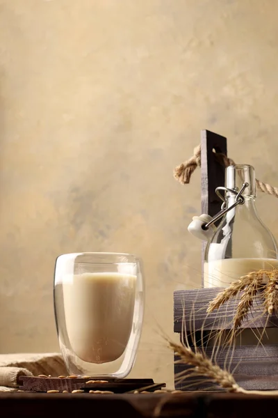 有机早餐饮料 在玻璃瓶中加入无麸质和乳糖燕麦牛奶 在木制背景中加入玻璃杯 乡村风格 健康概念 复制空间 纵向立场 图库照片
