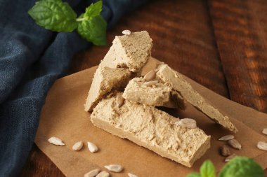 Doğal vejetaryen ürünü. Ahşap zemin üzerinde mavi peçeteli parşömen kağıdının üzerindeki ayçiçeği halkası. Kırsal tarzda. Üst Manzara. Düz yatıyordu.