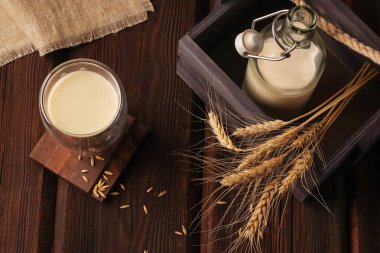 Vejetaryen organik kahvaltı içeceği. Cam bir şişede glüten ve laktozsuz yulaf sütü ve tahta arka planda bir kutuda bir bardak. Kırsal tarzda. Sağlık kavramı