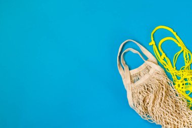 Ürünlerin teslimatı. Mavi arka planda tekrar kullanılabilir ekolojik alışveriş torbaları. Sıfır atık. Düz yatıyordu. Boşluğu kopyala.