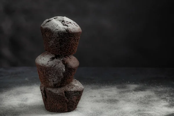 平衡新鲜的甜巧克力松饼与粉状糖的黑色背景 低调点复制空间 — 图库照片