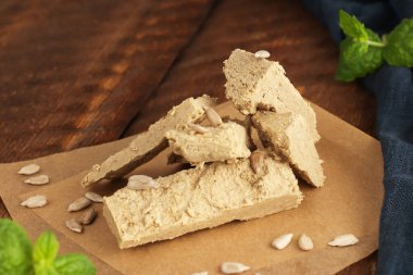 Ahşap zemin üzerinde mavi peçeteli parşömen kağıdının üzerindeki ayçiçeği halkası. Doğal vejetaryen ürünü. Kırsal tarzda. Üst Manzara. Düz yatıyordu