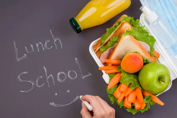 午餐盒与三明治 新鲜蔬菜和水果 一瓶果汁在黑暗的背景 粉笔写午餐学校 对细菌和病毒的卫生和保护 — 图库照片